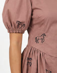 Close-up of the Fanm Mon Aviva Dress showing detailed black equestrian horse embroidery across the bodice, puff sleeve, and gathered skirt.