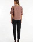 Backview of Model in Cait Blouse in Espresso showcasing puff sleeves and back keyhole button detail.