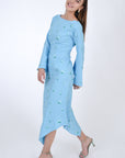 Fanm Mon Choupet Asymmetrical Linen dress, side view. Features long bell sleeves, a boat neckline and hits mid length. Detailed with intricate floral-inspired embroidery a Fanm Mon signature.