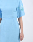Linen Naif Detail view of sleeve, embroidery, and waist belt.