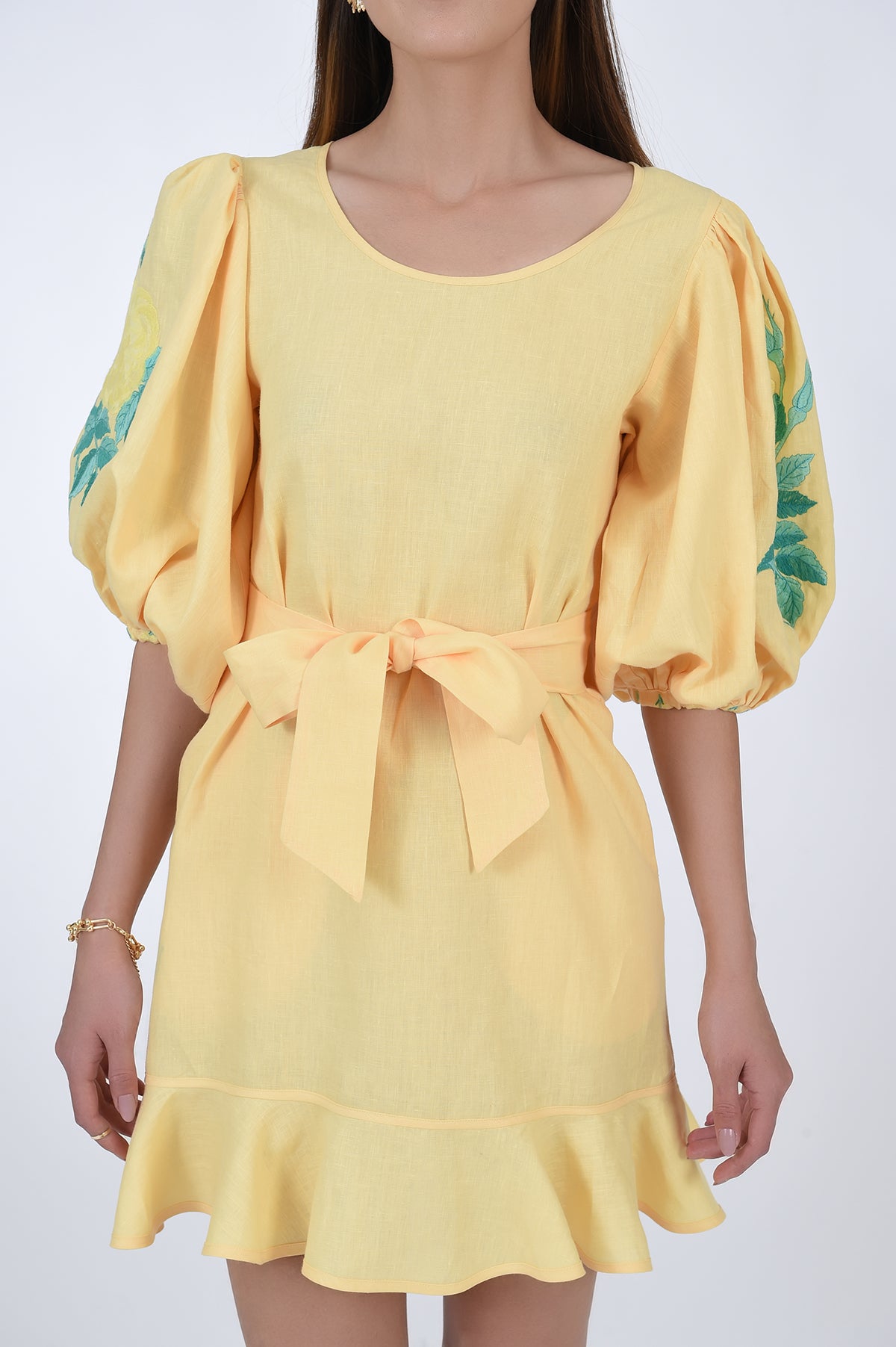 Naril Linen Dress Detail View, showcasing waist belt, ruffle hemline, and sleeves with embroidery detail.