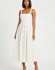 Model in Arya Dress, a romantic midi dress adorned with delicate hydrangea embroidery, designed for summer celebrations and timeless occasion dressing.