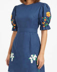 Close-up of the Cansel Dress showcasing tulip embroidery on the sleeves and jasmine embroidery along the skirt.