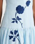 Close-up of the Paola Dress showcasing oversized blue floral embroidery and gathered skirt detailing.