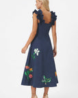 Back view of embroidered midi dress with ruffled straps and floral embroidery extending across the skirt.