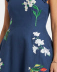 Close-up of hand-placed jasmine blossom, orchid, and tropical floral embroidery on the bodice.