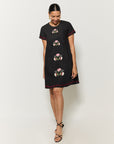 Woman wearing a black dress with floral embroidery on a white background