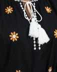 Close-up of the Fanm Mon Lavina Dress highlighting floral embroidery, contrast neckline detailing, and white tassel ties.