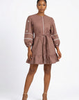 Fanm Mon Noen Dress on model featuring daisy floral embroidery, long blouson sleeves, braided tie waist and ruffled hem