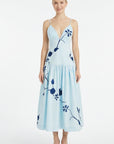 Fanm Mon Paola Dress featuring oversized blue floral embroidery, plunging V-neckline, adjustable straps, and gathered midi skirt.