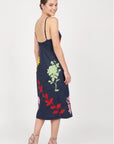 Back view of model wearing Fanm Mon Pout Dress with colorful floral embroidery and delicate open-back straps