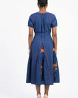 Back view of the Fanm Mon Venya Dress featuring contrast embroidery, a self-tie waist, and floral embroidered gathered skirt.