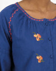 Detail of Fanm Mon Akik Top showing floral embroidery, contrast neckline trim and covered buttons