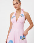 Detail of model wearing the Fanm Mon Ayna Dress with vivid blue floral embroidery accented by green leaves and yellow centers.
