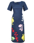Fanm Mon Blanka Dress in indigo blue featuring a square neckline, short sleeves, fitted waist, and colorful rose embroidery across the midi skirt.