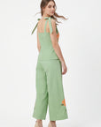 Back view of model wearing Fanm Mon Collette Set in green showing the fitted peplum top, tied shoulder straps, and cropped wide-leg trousers with floral embroidery