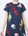 Close-up of the Fanm Mon Gence Dress in navy highlighting pink rose embroidery, red botanical stems, and colorful floral motifs across the bodice