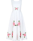 Fanm Mon Hazel Dress in white featuring a sleeveless round neckline, fitted bodice, and pink rose embroidery with green foliage across the waist and flowing A-line midi skirt.