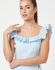 Close-up of Fanm Mon July Dress in light blue featuring a ruffled square neckline, flutter sleeves, and delicate white floral embroidery