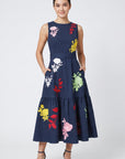 Model wearing Fanm Mon Mihrap Dress with colorful botanical embroidery, tiered skirt and side pockets