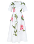 Fanm Mon Rumen Dress in white featuring a round neckline, short sleeves, fitted bodice, and oversized pink rose embroidery with green foliage across the A-line midi skirt.