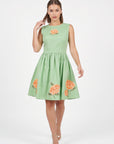 Model wearing the Fanm Mon Seher Dress with orange floral embroidery, a fitted sleeveless bodice and gathered mini skirt.