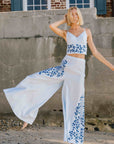 Fanm Mon Cali Pant Lifestyle Image. 2 Piece Linen Top and Pants Set. Top features intricate embroidery detail and a side button closure, while the wide-leg pants boast a matching embroidery detail and side button closure for a cohesive look.