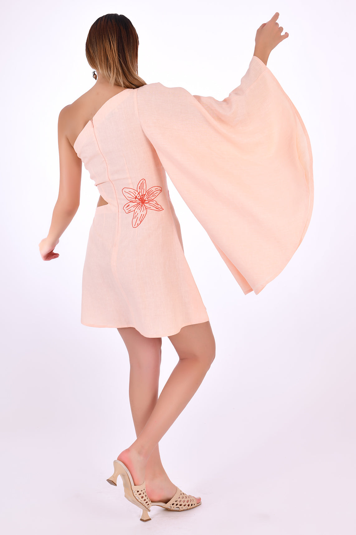 Fanm Mon Kame Linen Dress, showcasing back view with back embroidery detail and one shoulder bell sleeve. 