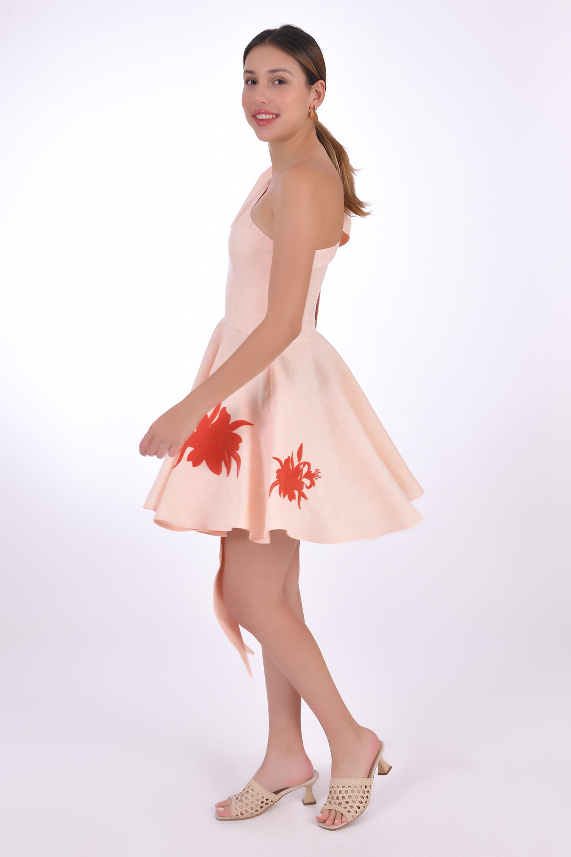 Fanm Mon Eftelya Linen Dress (Side View without Bow). Mini One Shoulder Linen Dress with a full circle skirt, detachable bow detail, hidden side zipper, and embroidery on the skirt.
