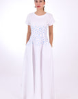 Fanm Mon Firsdevs Linen Dress, Front View. Timeless Tea-length Luxurious Linen Dress. 100% linen, Made to Measure. This classic dress is the perfect expression of modern elegance in an A-line silhouette that features cap sleeves and round neck, embellished with both front and back waist embroidery, and subtle side pockets.