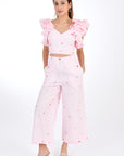 FANM MON ANAIS 2 Piece Linen Top and Pants Set. Sleeveless top features ruffles with intricate embroidery detail and back detail of bow and button closure, while the wide-leg pants boast a matching embroidery detail and on-seam pockets for a cohesive look. Front View.