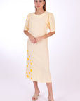 Doga Midi Linen Dress, Front View. Featuring a peephole open back and button closure. Round neck, with a belt for the waist (can be worn with or without), and features front embroidery detail. 