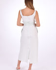 Fanm Mon BAHAR Midi Dress Back View showcase back zipper and slit.. Sleeveless Midi Linen Sheath Dress. Featuring a smocked waistband with ruffle trim and hand-embroidered floral pattern.