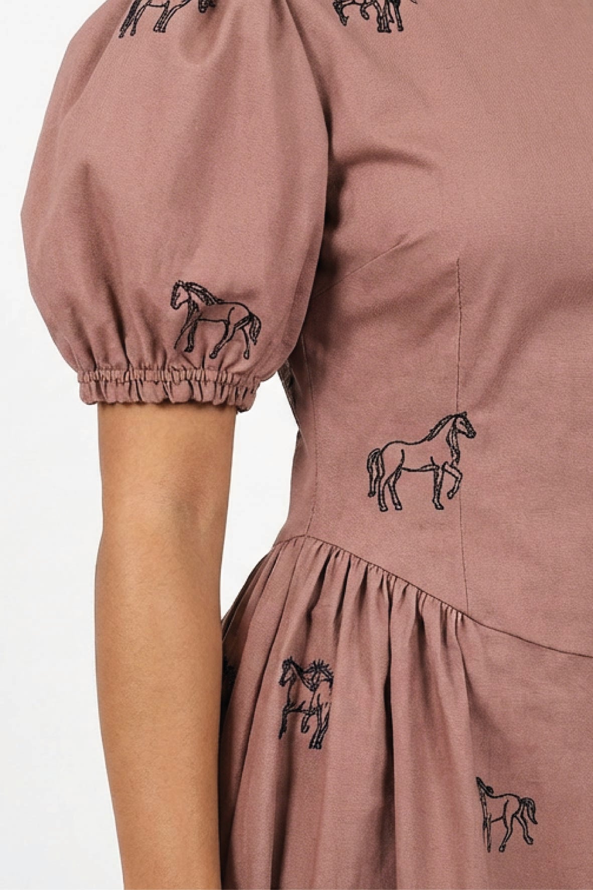 Close-up of the Fanm Mon Aviva Dress showing detailed black equestrian horse embroidery across the bodice, puff sleeve, and gathered skirt.