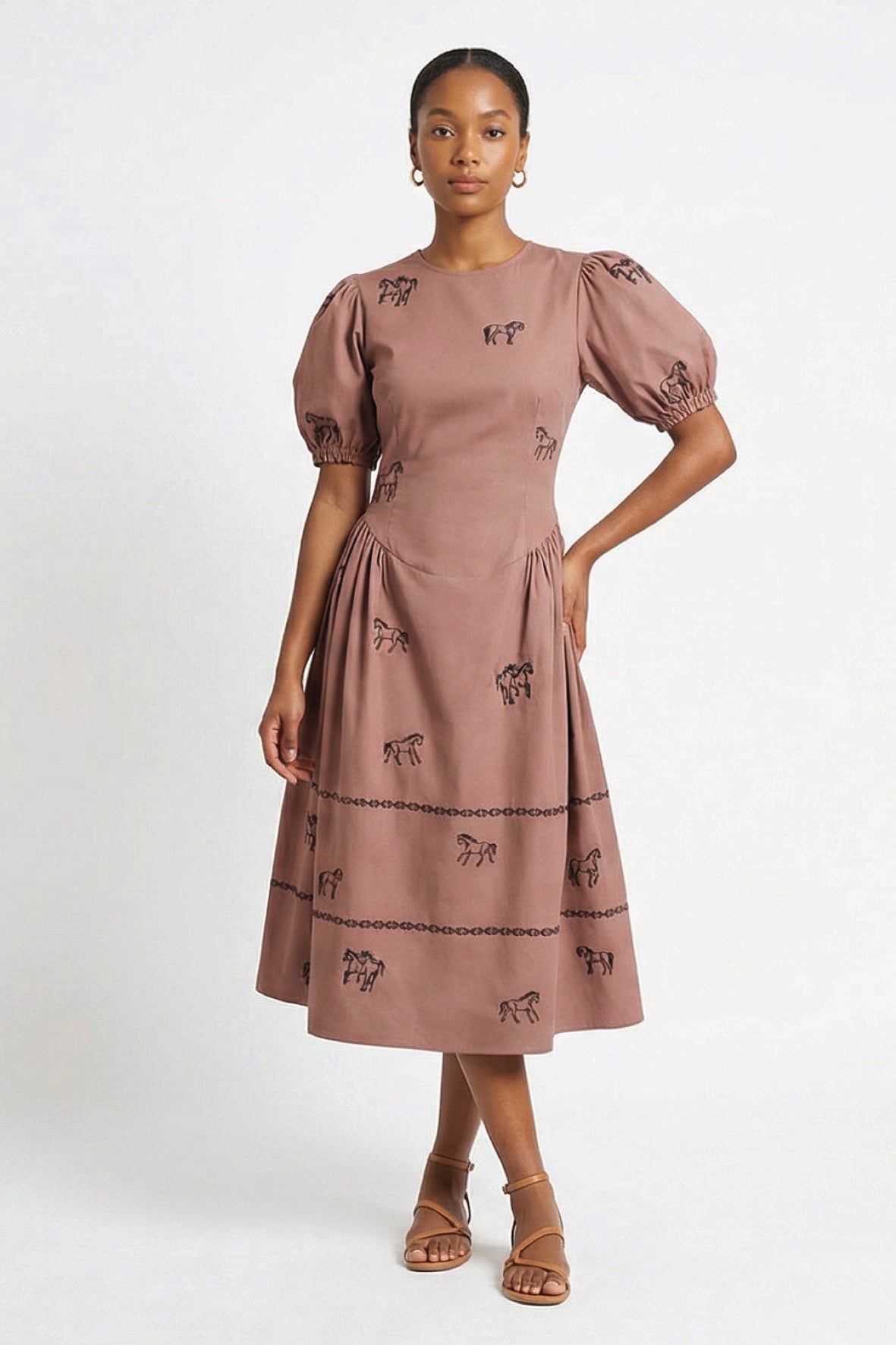 Model wearing the Fanm Mon Aviva Dress featuring scattered black horse embroidery, short puff sleeves, a fitted bodice, and a gathered drop-waist midi skirt.