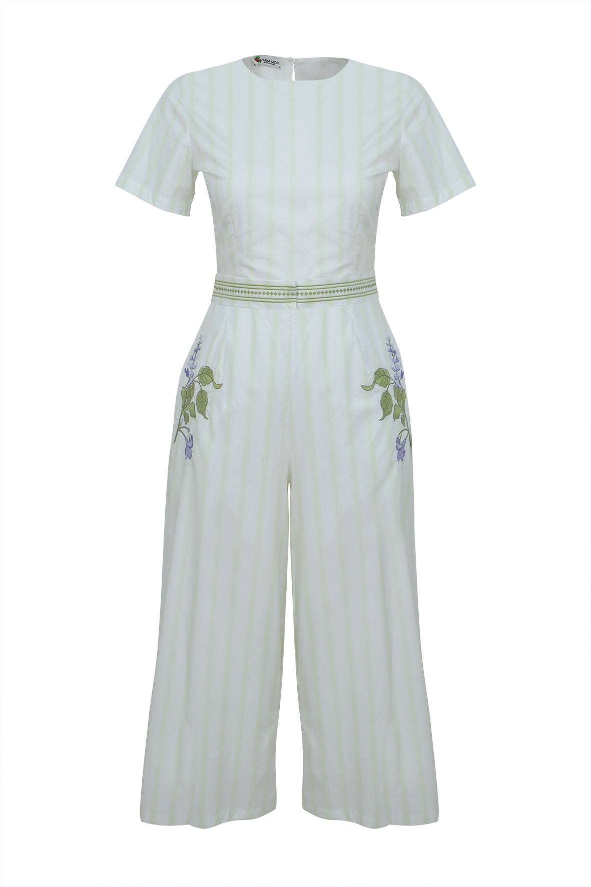 White jumpsuit with green embroidery on a white background. Fanm Mon Birgul Jumpsuit.