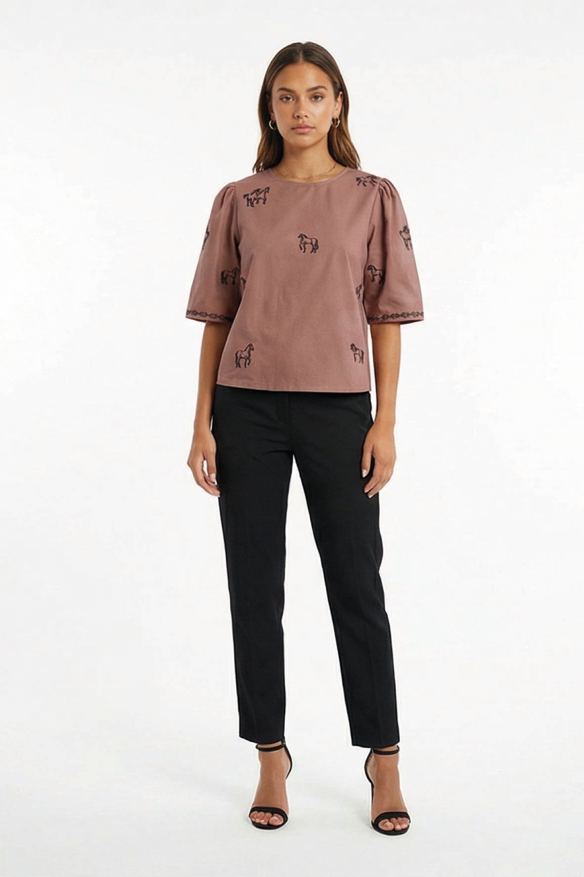 Model wearing Fanm Mon Cait shor sleeve top with small black embroidered horse motifs, against a plain white studio background.