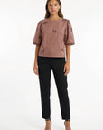 Model wearing Fanm Mon Cait shor sleeve top with small black embroidered horse motifs, against a plain white studio background.