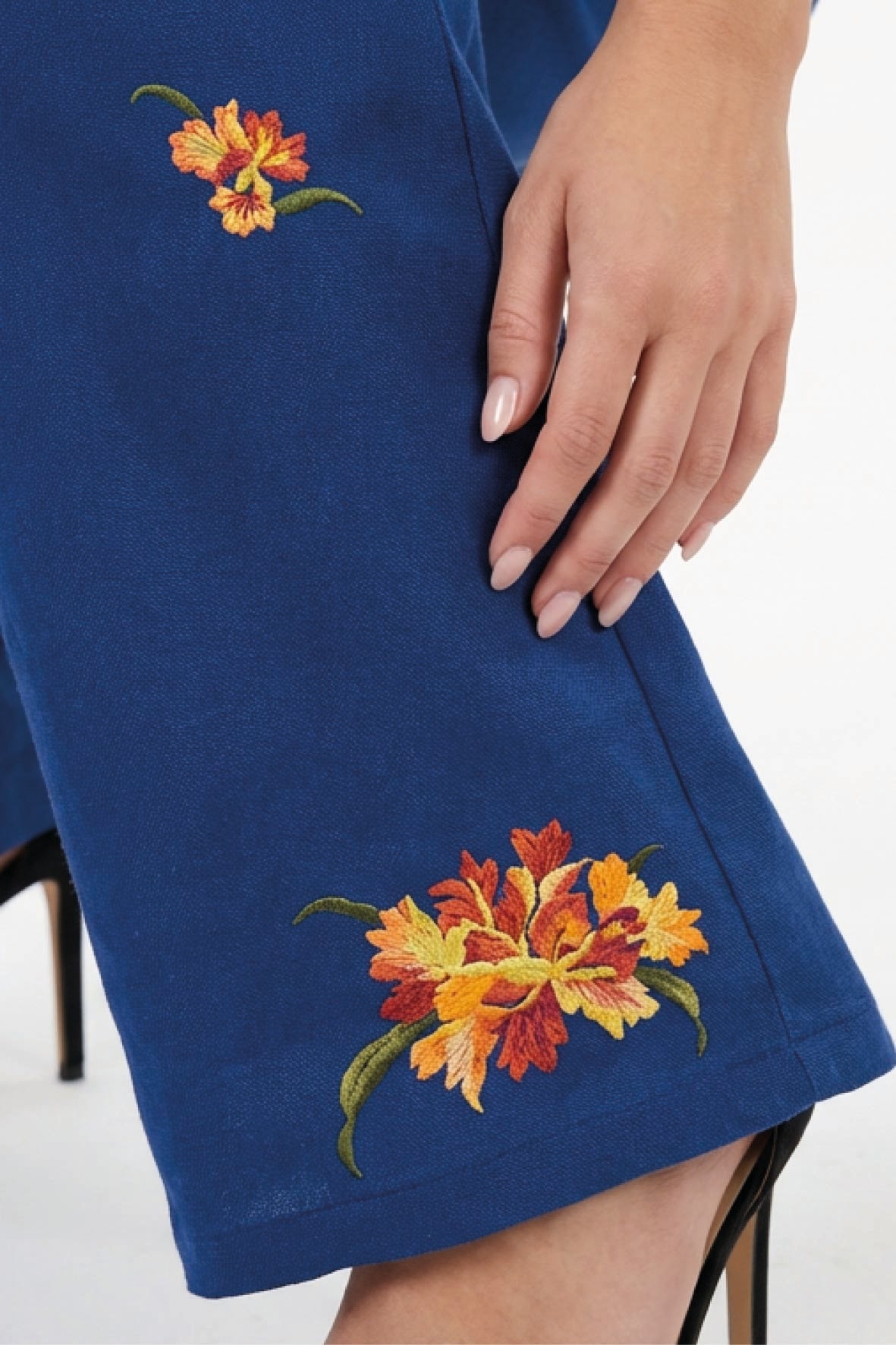 Fanm Mon Cora Pant detail featuring orange and red fire-inspired floral embroidery with green stems and leaves