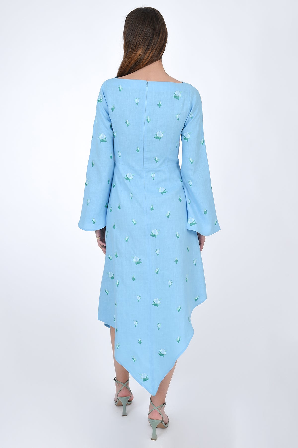 Fanm Mon Choupet Asymmetrical Linen dress, back view.  Features long bell sleeves,  a boat neckline and hits mid length. Detailed with intricate floral-inspired embroidery a Fanm Mon signature. 