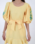 Naril Linen Dress Detail View, showcasing waist belt, ruffle hemline, and sleeves with embroidery detail.