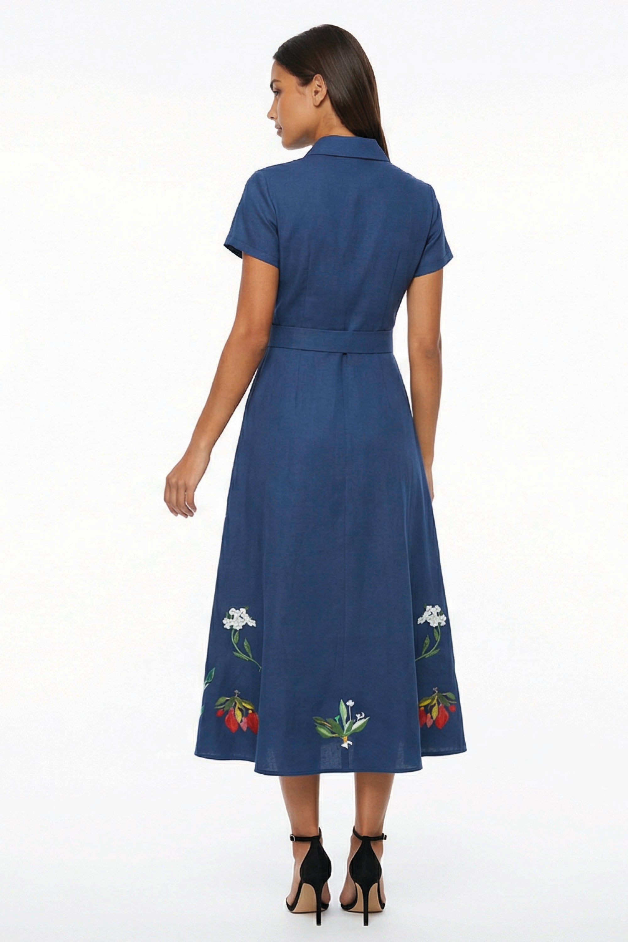 Back view of the Fanm Mon Elena Dress with short sleeves, defined waistband, and botanical embroidery placed around the lower skirt.