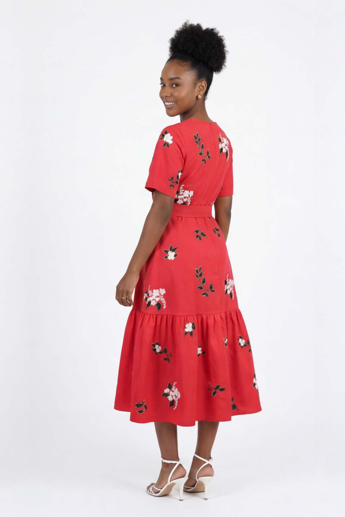 Back view of the Liza Dress with scattered floral embroidery, tailored waist detailing, and a gathered midi skirt.