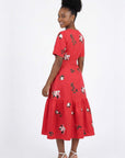 Back view of the Liza Dress with scattered floral embroidery, tailored waist detailing, and a gathered midi skirt.