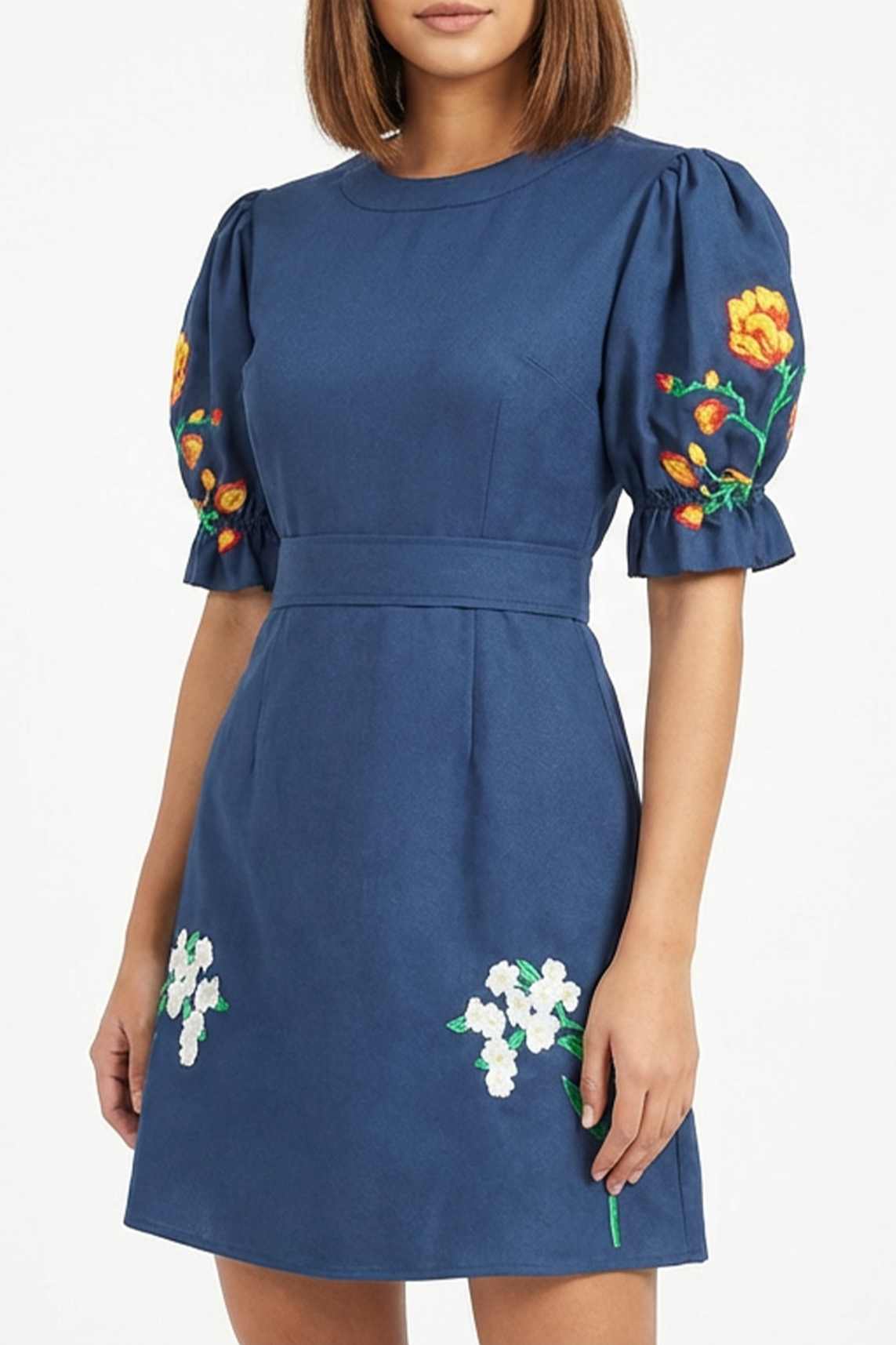 Close-up of the Cansel Dress showcasing tulip embroidery on the sleeves and jasmine embroidery along the skirt.