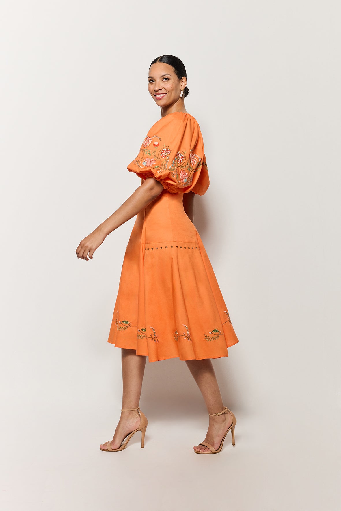 Side view of model wearing the Cacem Dress showcasing the lines and flare of the skirt. 