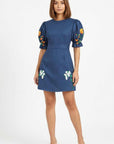 Model wearing the Fanm Mon Cansel Dress with embroidered puff sleeves, crew neckline, and floral embroidered skirt.