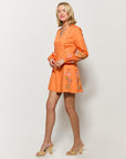 On Model sideview of Chorzele mini dress in orange cotton.