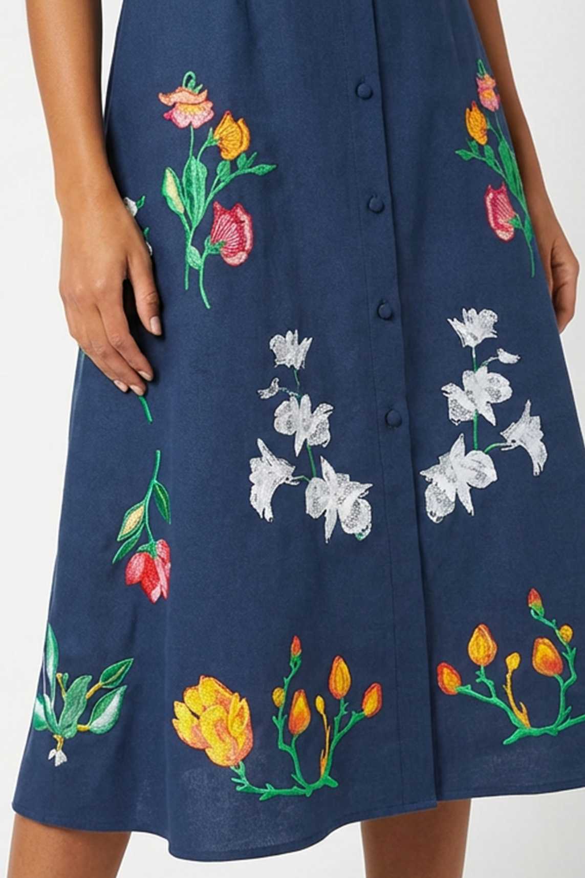 Close-up of hand-placed tulip, jasmine, and lily embroidery featured on the skirt of the Fanm Mon Elena Dress.