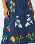 Close-up of hand-placed tulip, jasmine, and lily embroidery featured on the skirt of the Fanm Mon Elena Dress.